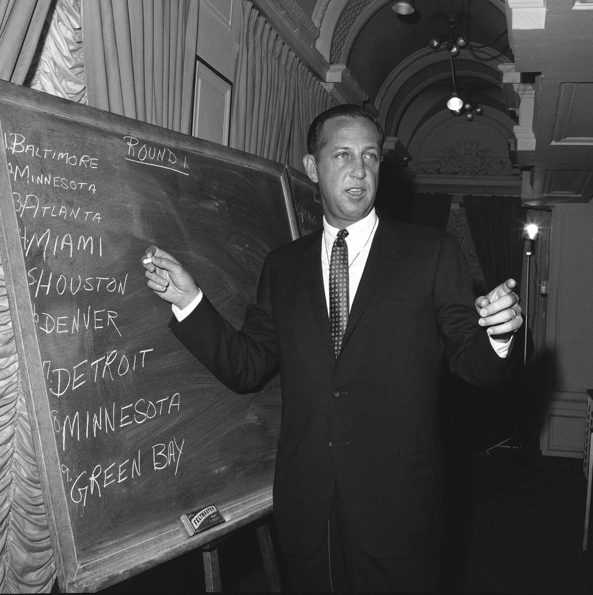 FILE - In this March 14, 1967, file photo, NFL commissioner Pete Rozelle works at on a blackboa ...
