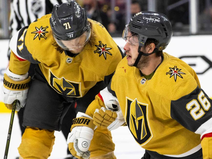 Golden Knights center Mattias Janmark (26) is helped to his feet by Golden Knights center Willi ...