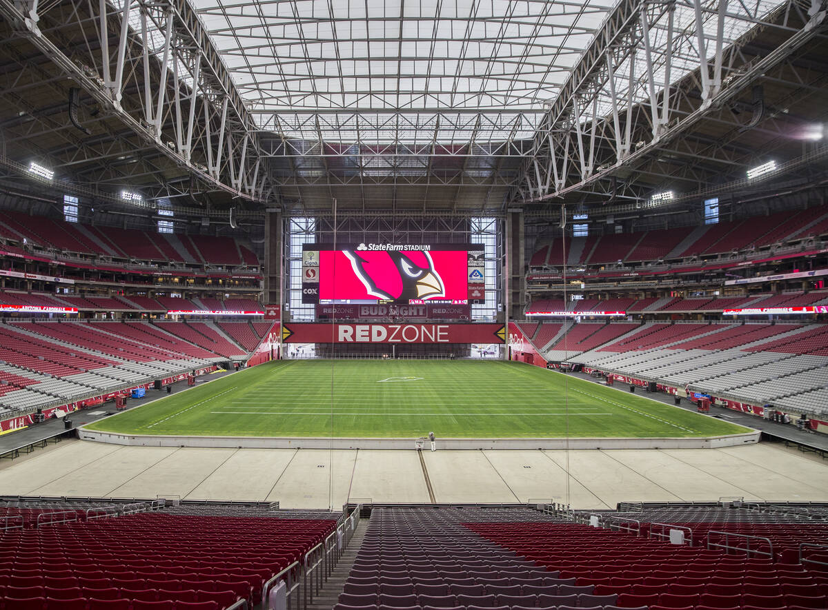 Engineer Don Kramer, middle, oversees the installation of the grass field tray system in prepar ...