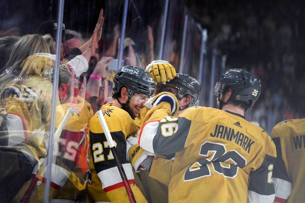 Vegas Golden Knights defenseman Shea Theodore (27) is congratulated after scoring in overtime a ...