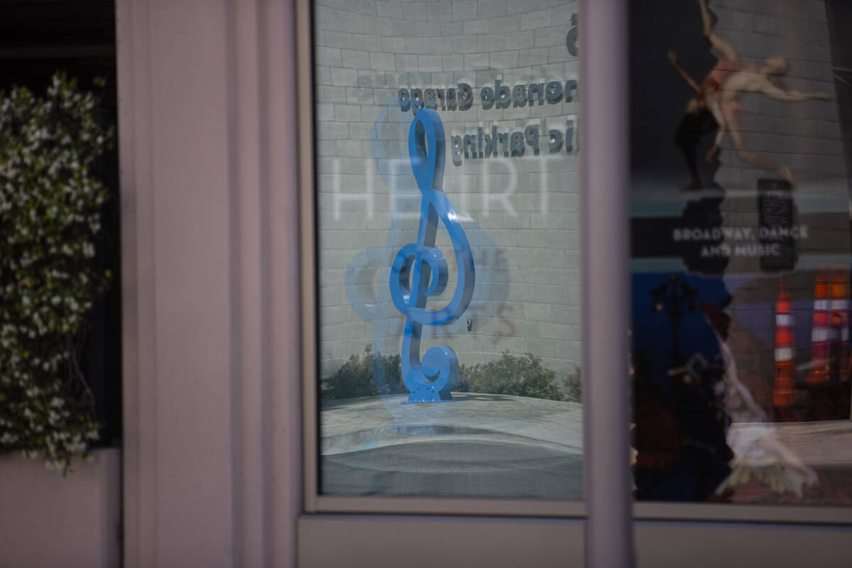 A steel treble clef is reflected in a window after the dedication of the "Larger Than Life ...