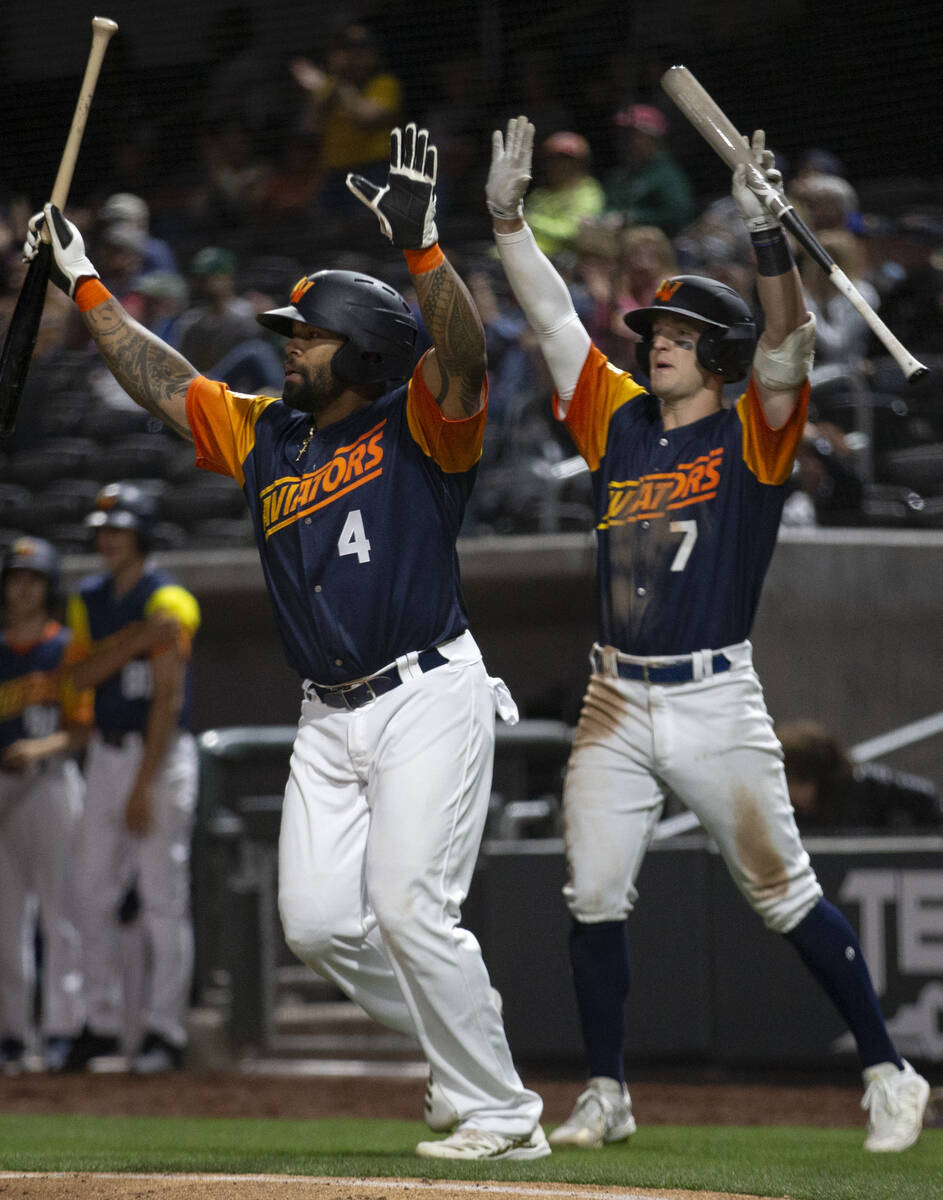 Las Vegas Aviators infielders Eric Thames (4) and Marty Bechina (7) cheer as their teammates re ...