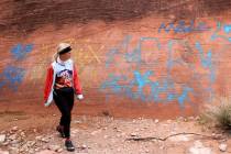 Heather Fisher, president of Save Red Rock, checks out new graffiti spray painted on rocks in t ...