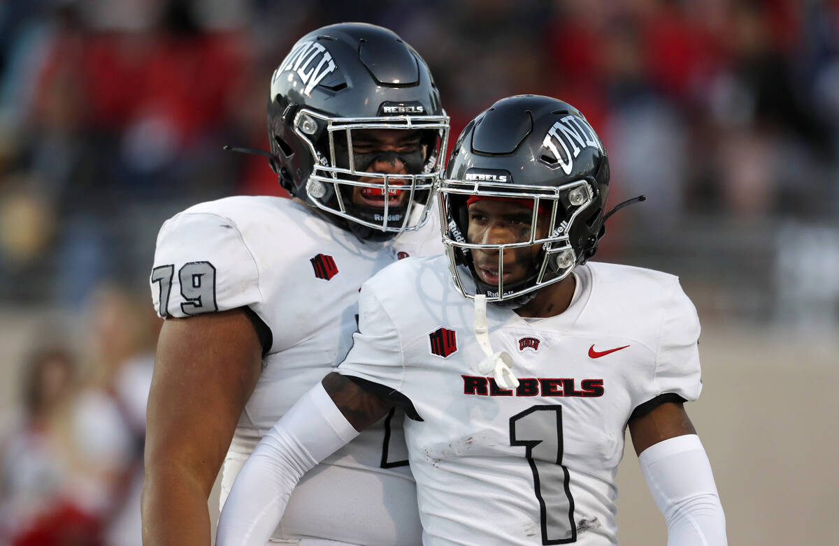 UNLV wide receiver Kyle Williams (1) is congratulated by offensive lineman Leif Fautanu (79) af ...