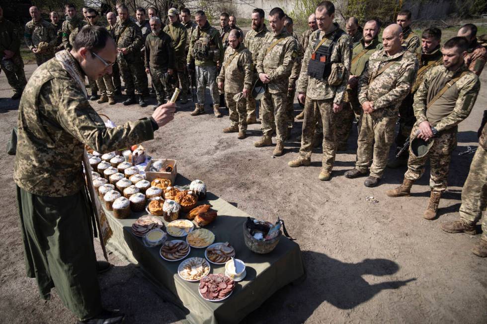 A military Orthodox priest blesses traditional food during the Easter celebration at the frontl ...