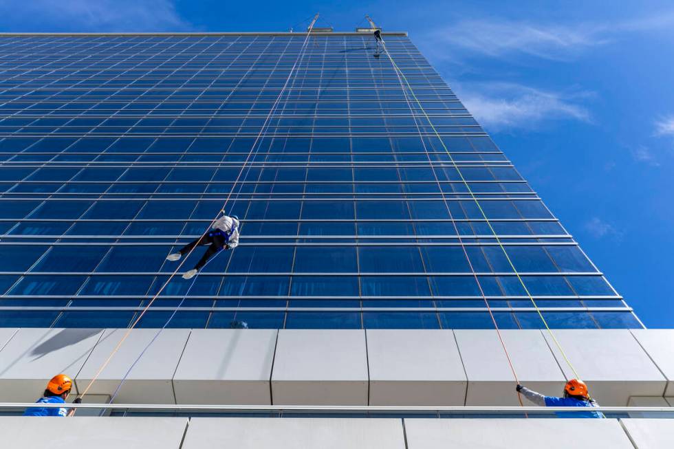 Rappellers begin to work their down from the roof at the Opal Tower at Virgin Hotels Las Vegas ...