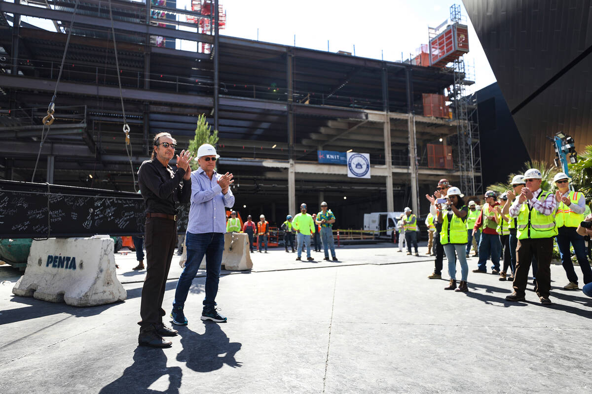 Developer partners Brett Torino, left, and Paul Kanavos, right, speak to workers at the constru ...