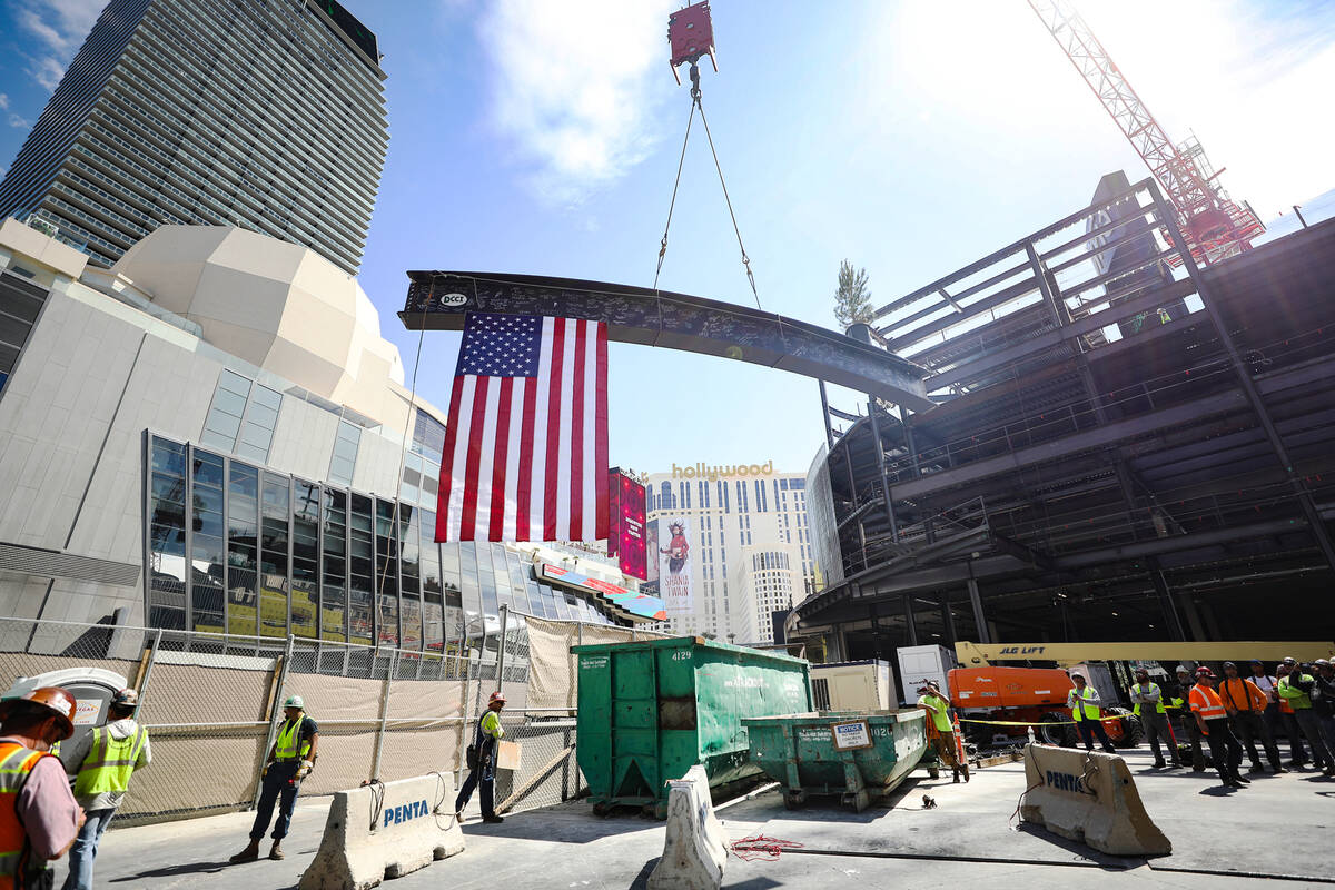 The last beam is hoisted towards the building at the topping off ceremony for Project63, a new ...