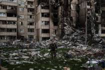 A Ukrainian serviceman walks amid the rubble of a building heavily damaged by multiple Russian ...