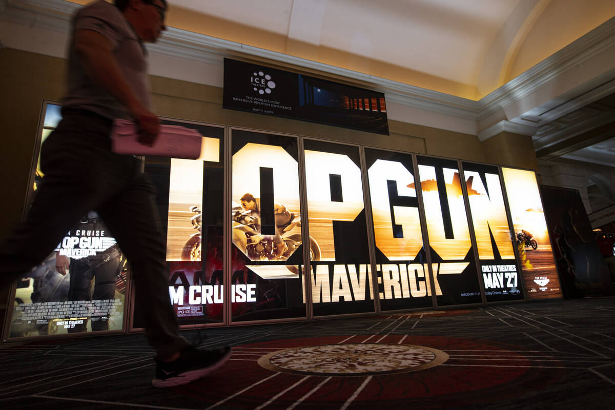 An attendee walks by a display for “Top Gun: Maverick” at the CinemaCon trade sho ...