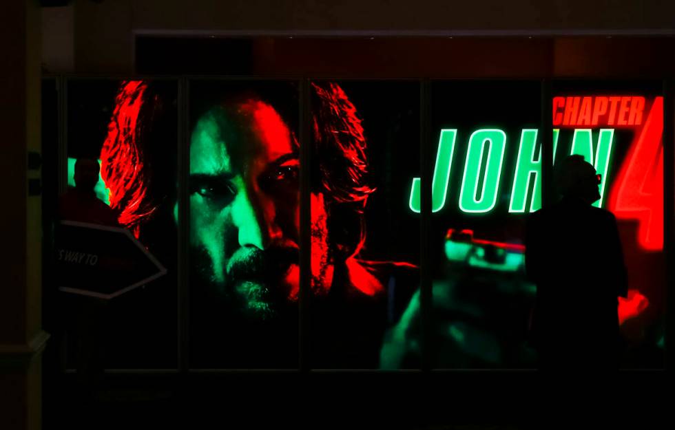 An attendee walks by a display for “John Wick: Chapter 4” at the CinemaCon trade ...