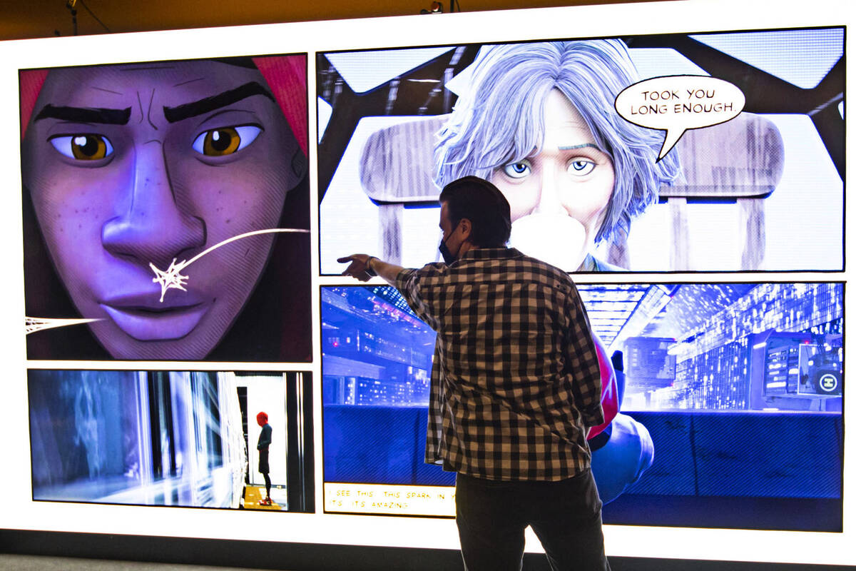 Benjamin Watts of IGN tries out an interactive Spider-Man' display at the CinemaCon trade show ...