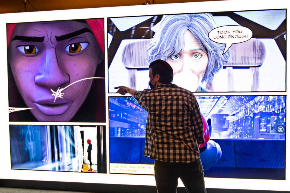 Benjamin Watts of IGN tries out an interactive Spider-Man' display at the CinemaCon trade show ...