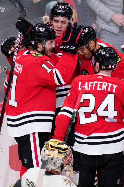 Chicago Blackhawks right wing Taylor Raddysh (11) celebrates with teammates after scoring a goa ...