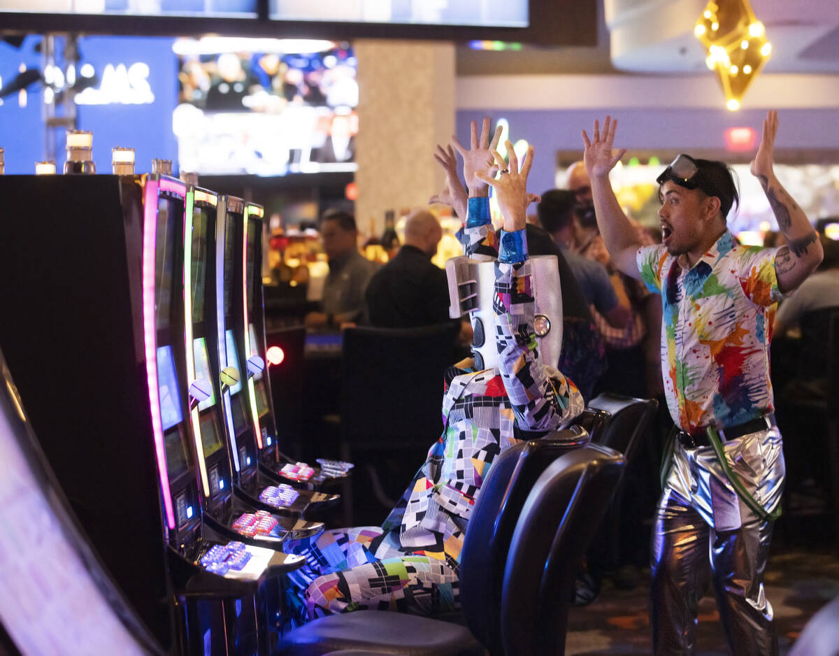 Colorfully dressed guests play the slots during the reopening party at the Palms on Wednesday, ...