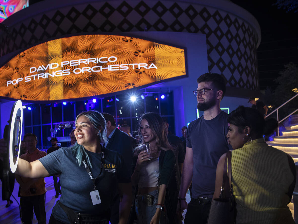 Ruthie Clarissa Torres, left, takes guests photos during an opening night party at Kaos at the ...