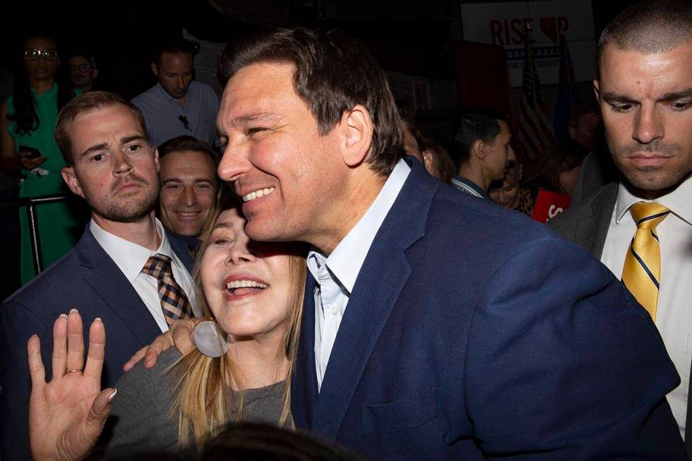 Florida Gov. Ron DeSantis poses for photos with an attendee while Nevada Republican U.S. Senate ...