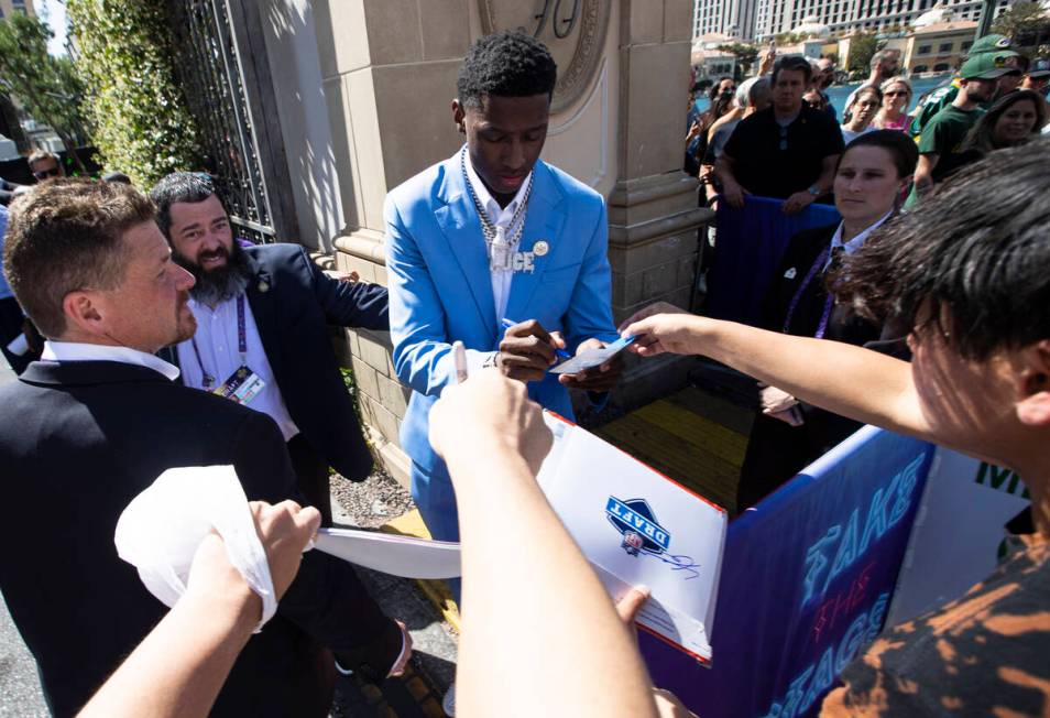 NFL draft prospect Ahmad "Sauce" Gardner signs items for fans during the first day of ...