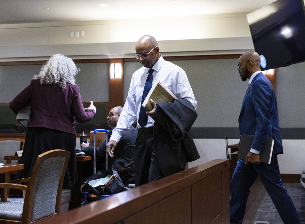 Wendell Melton, center, accused of killing his 14-year-old son in 2017, arrives in court with h ...