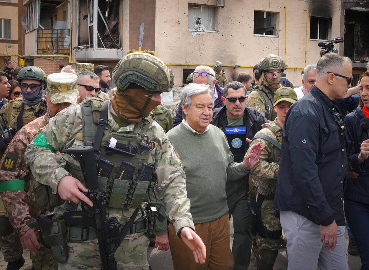 U.N. Secretary-General Antonio Guterres, center, looks at the houses destroyed by Russian shell ...