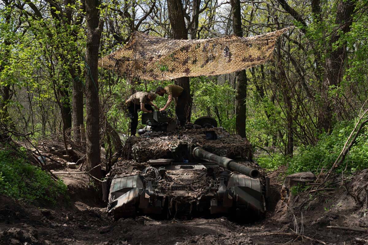 Ukrainian servicemen install a machine gun on the tank during the repair works after fighting a ...