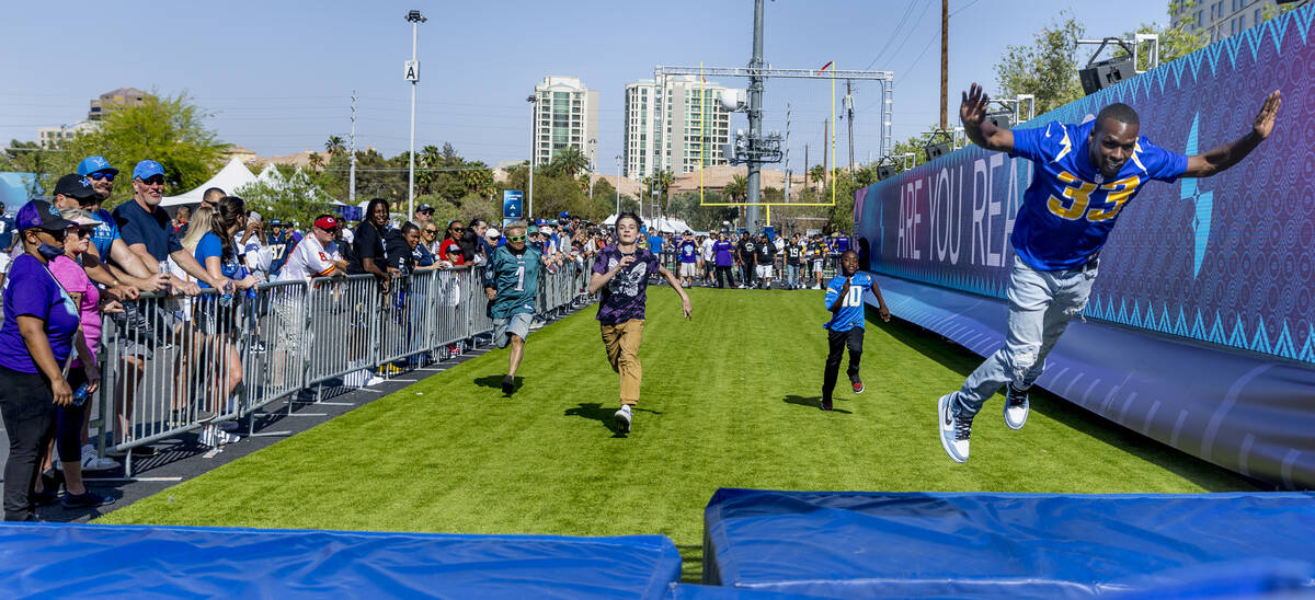A Los Angeles Chargers fan dives onto a mat after winning a 40-yard dash within the Draft Exper ...
