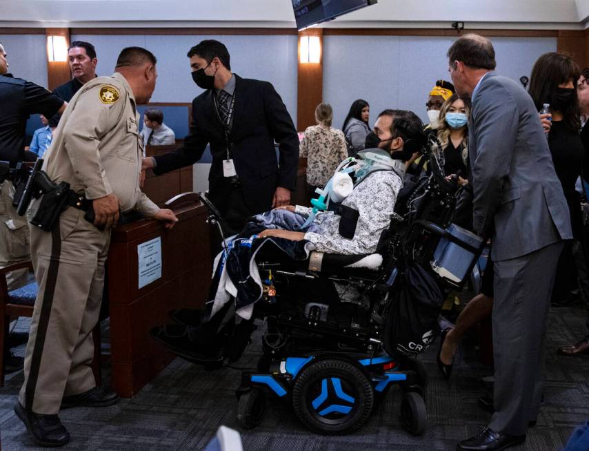 Metro officer Shay Mikalonis, center in a wheelchair, prepares to leave the courtroom after att ...