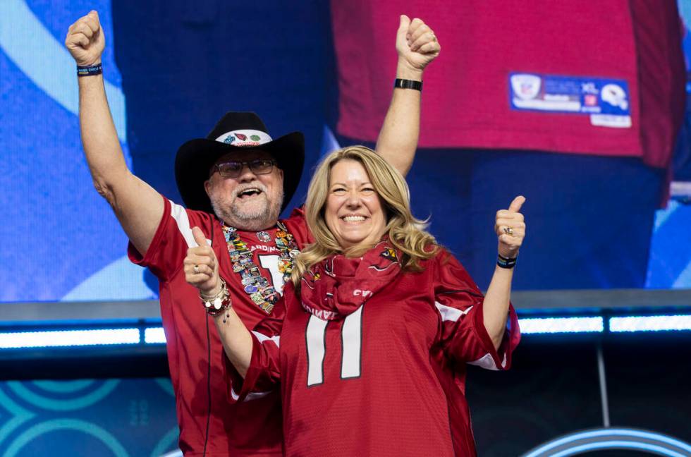 Rick and Lisa Wilcoxson, from Phoenix, Ariz, celebrate after learning they received tickets to ...