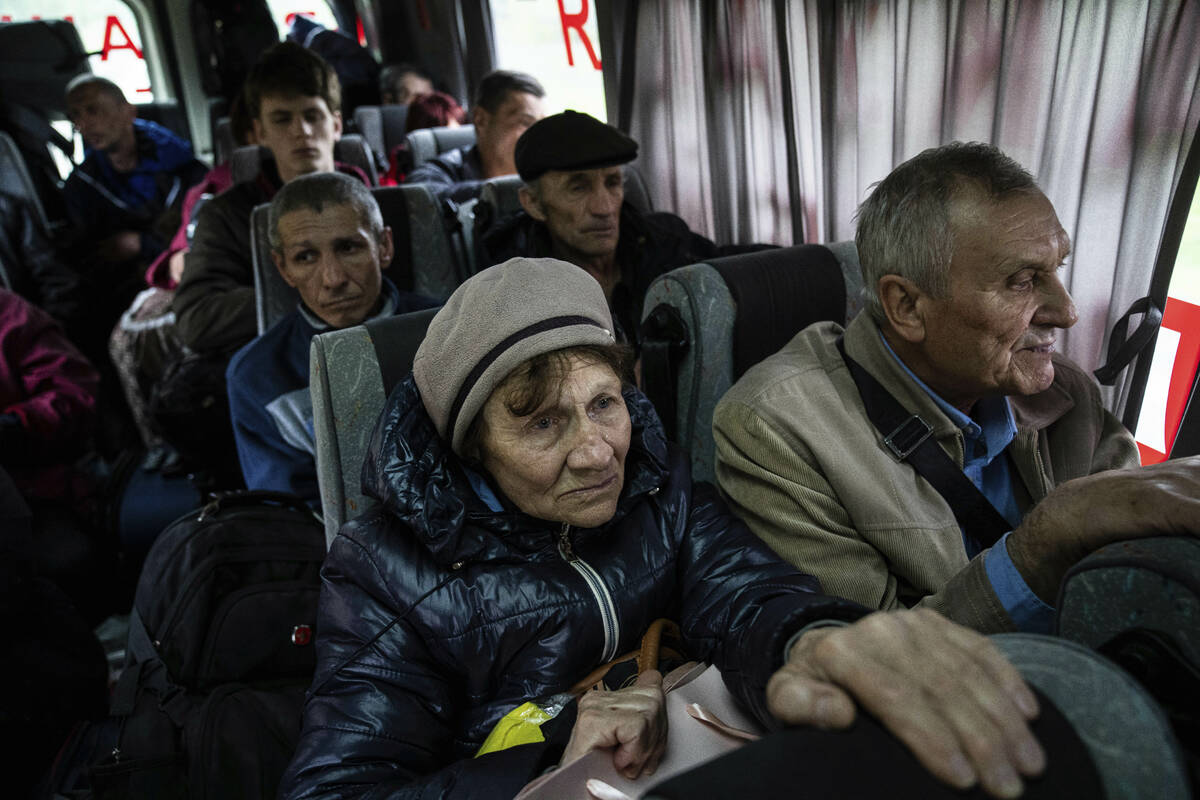 People sit in a bus during evacuation from Lyman, Donetsk region, eastern Ukraine, Saturday, Ap ...
