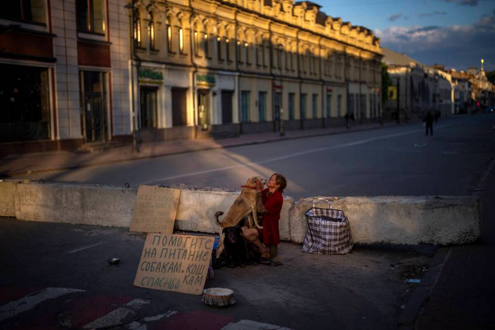 A woman begs for alms to feed her dogs in Kyiv, on Saturday, April 30, 2022. (AP Photo/Emilio M ...