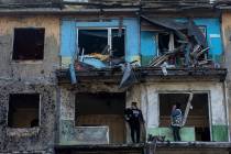 Local residents stand on the balconies of their apartments damaged by Russian shelling in Dobro ...