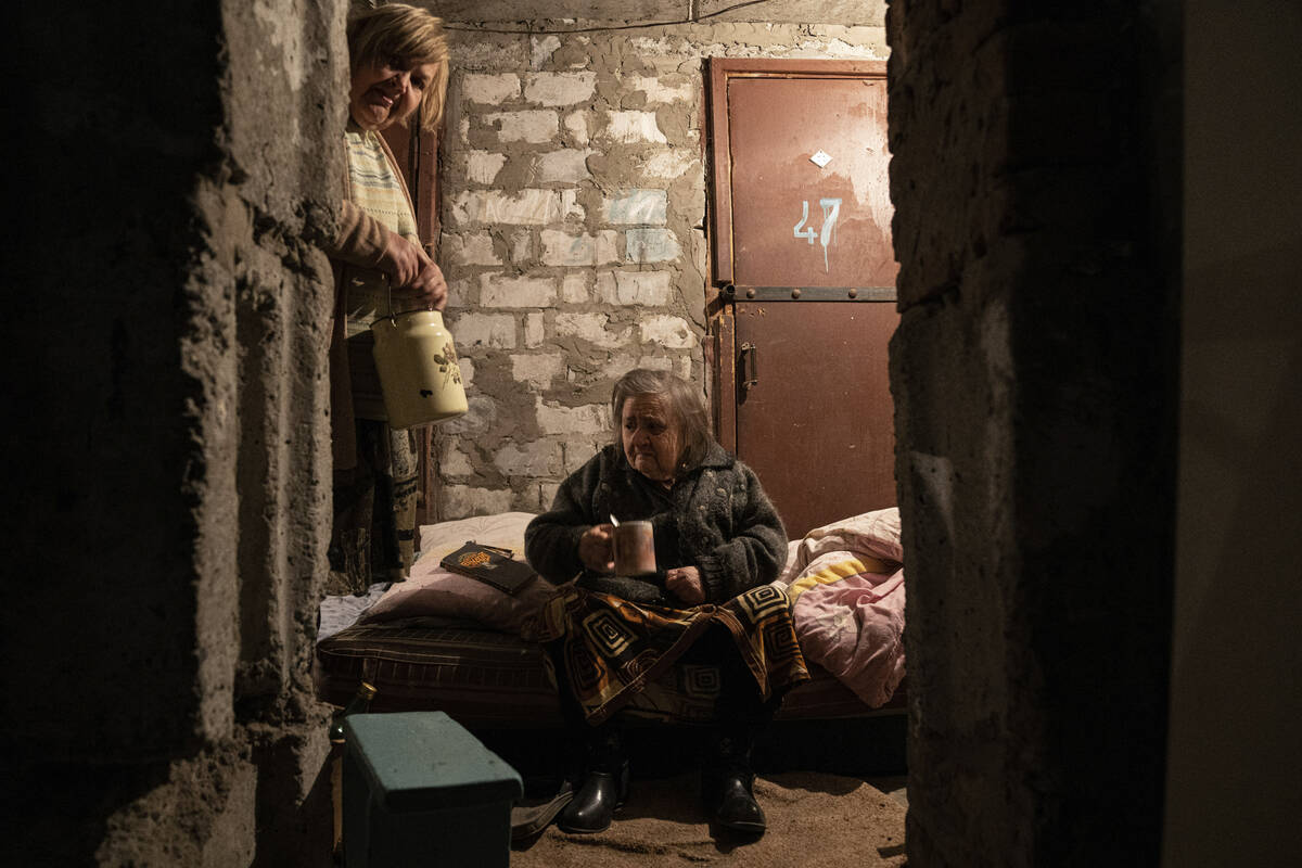 An elderly woman drinks tea at the basement of her house in Lyman, Donetsk region, eastern Ukra ...