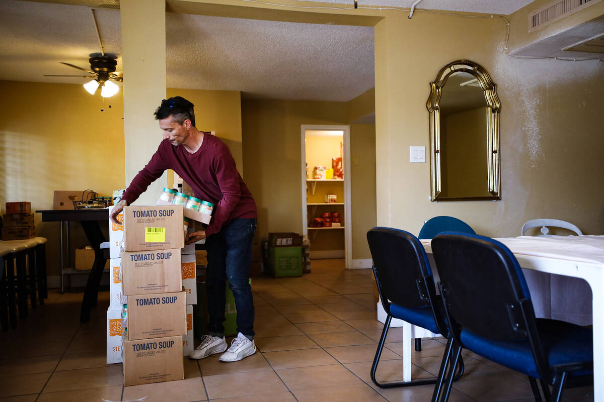 Manny Carvalho puts away food donations in the community room at Hebron, formerly known as Shar ...