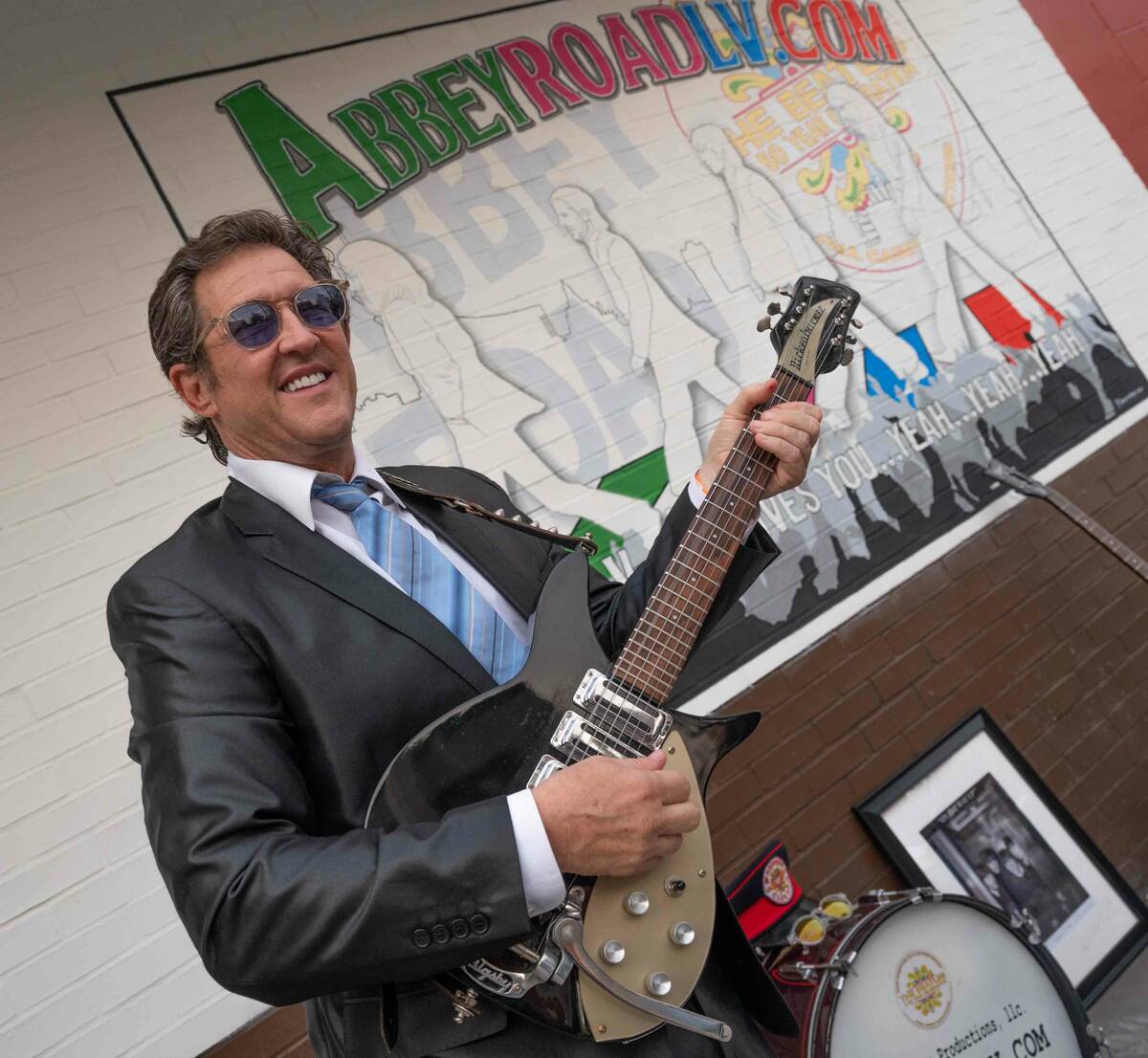 Paul Casey is shown playing a Beatles-style Rickenbacher guitar at a rededication event celebra ...