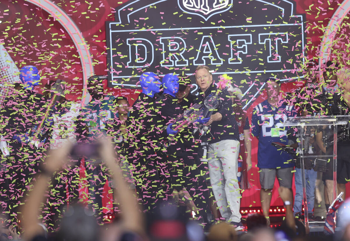 NFL Commissioner Roger Goodell shoots confetti into the crowd with members of the Blue Man Grou ...