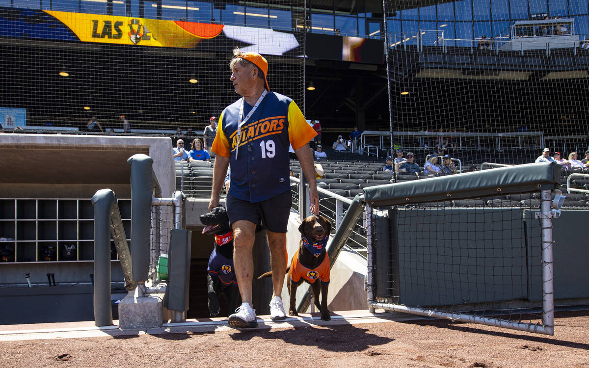 Fred Hassen, founder of Sit Means Sit dog training, walks onto the field with Las Veg ...