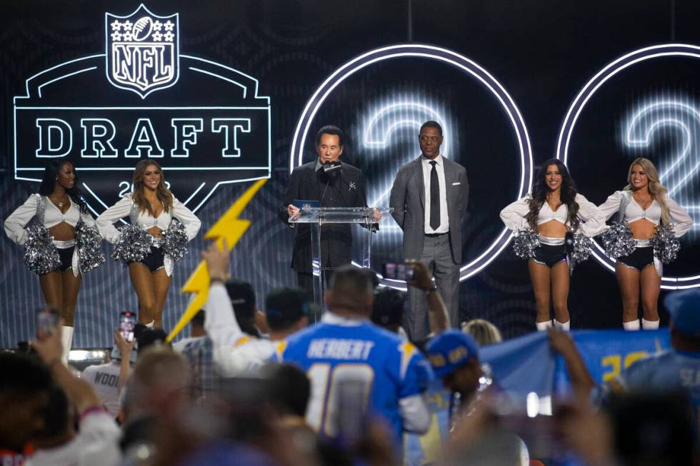 Wayne Newton stands on the stage with retired professional football player Marcus Allen to anno ...