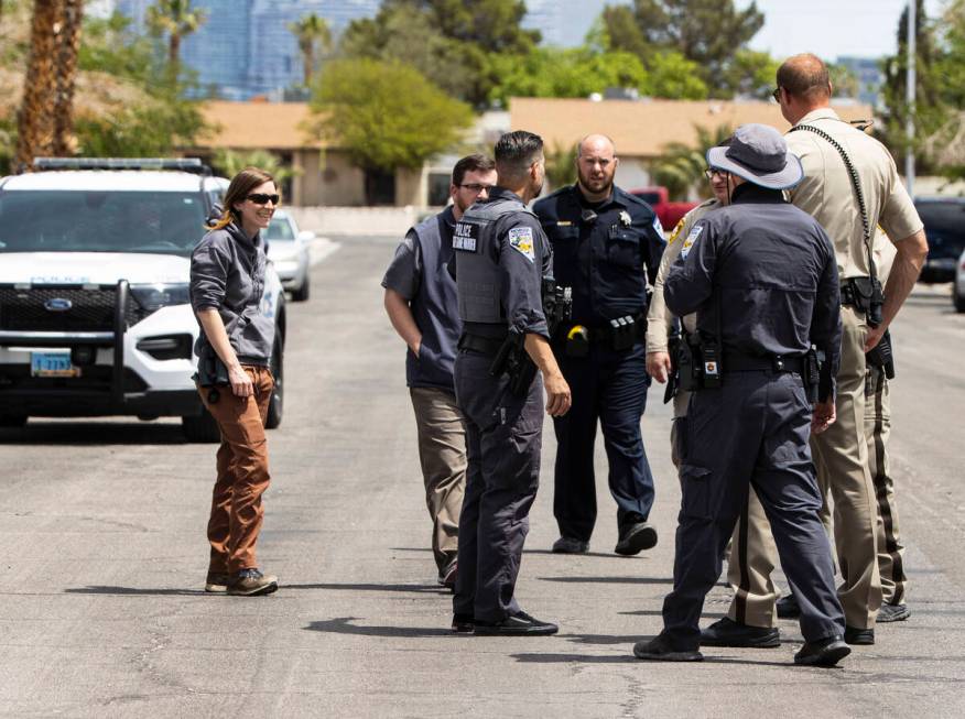 Las Vegas police officers and Nevada Department of Wildlife game warden gather around the area ...