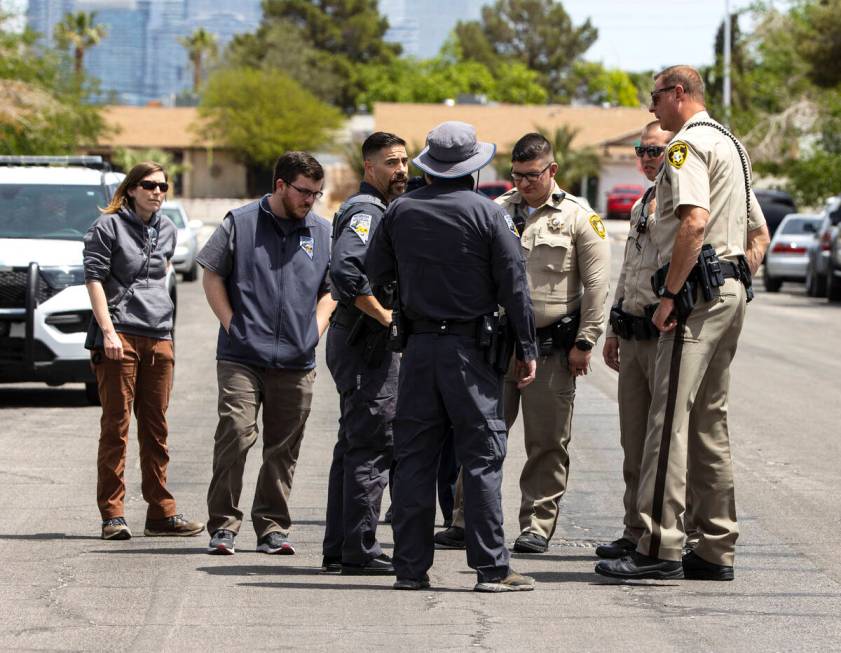 Las Vegas police officers and Nevada Department of Wildlife game warden gather around the area ...