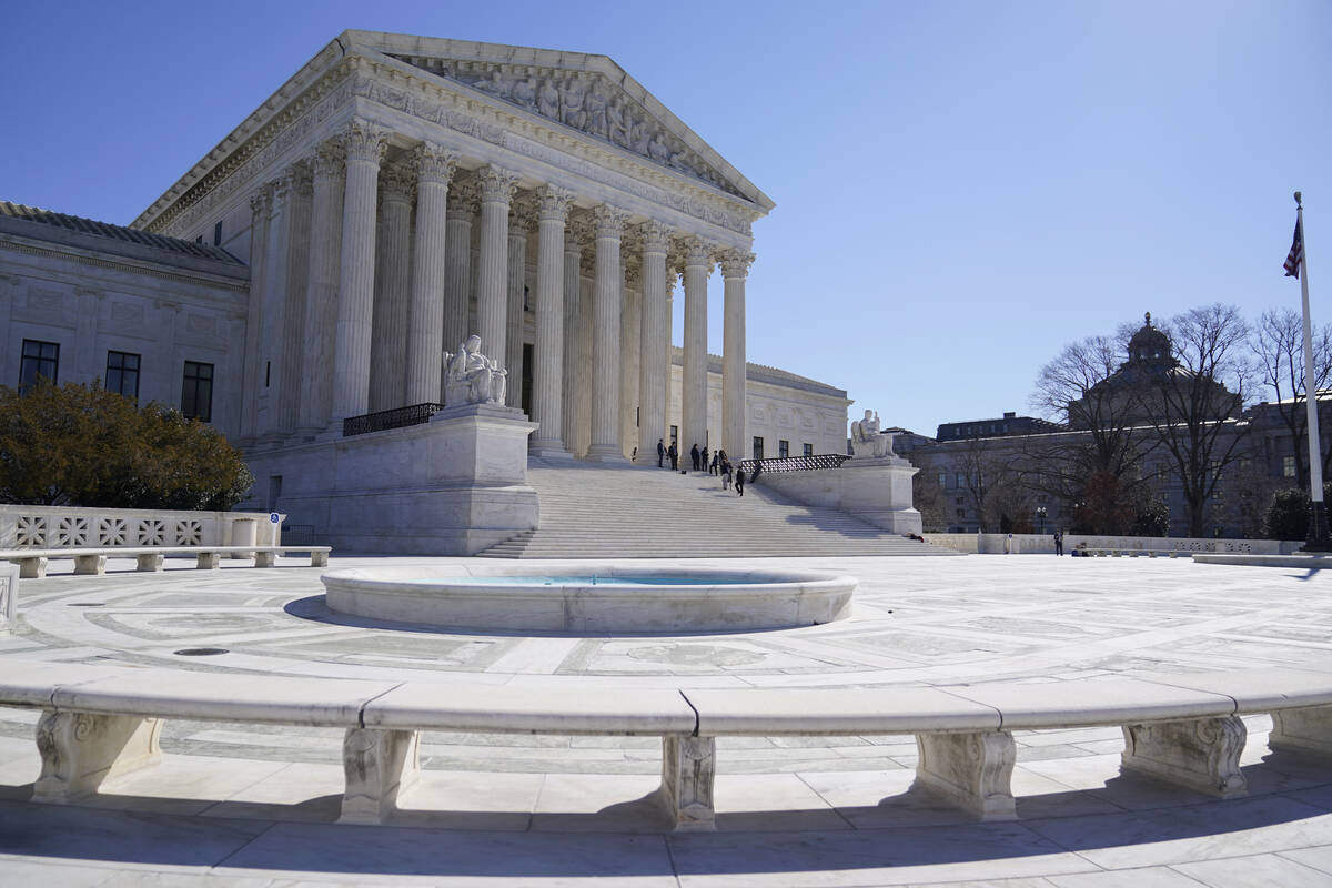 People stand on the steps of the U.S. Supreme Court, Feb.11, 2022, in Washington. (AP Photo/Ma ...