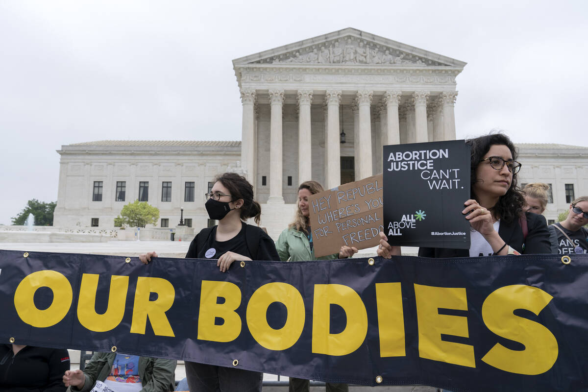 Demonstrators protest outside of the U.S. Supreme Court Tuesday, May 3, 2022 in Washington. A d ...