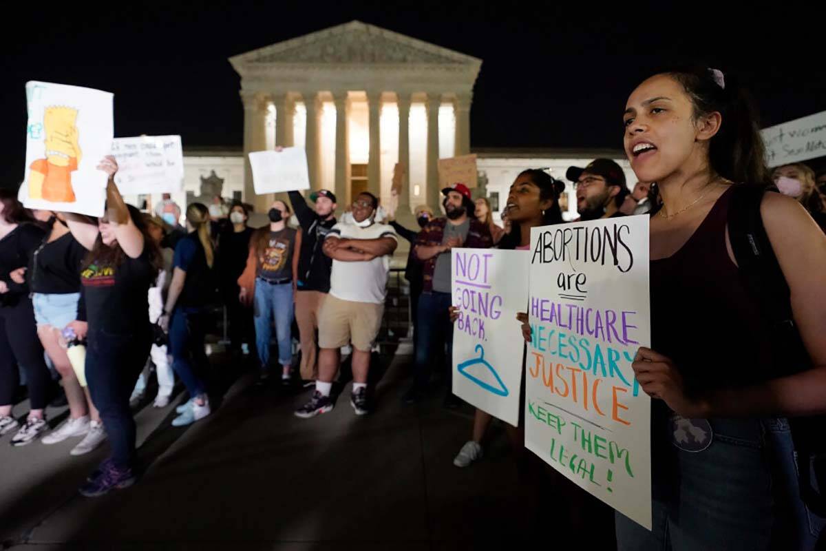 A crowd of people gather outside the Supreme Court, early Tuesday, May 3, 2022 in Washington. A ...
