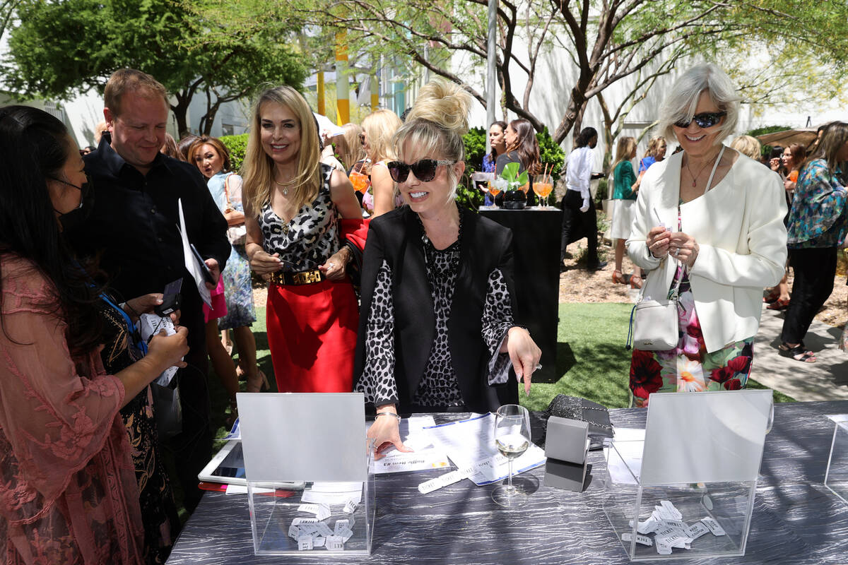Guests, including Sarah Hummel of Las Vegas, center, browse auction items during a Mother's Day ...