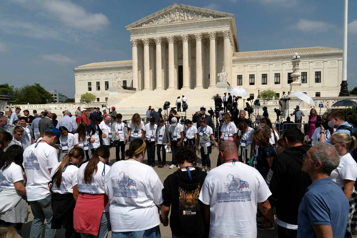 People pray outside of the U.S. Supreme Court Tuesday, May 3, 2022 in Washington. (AP Photo/Jos ...