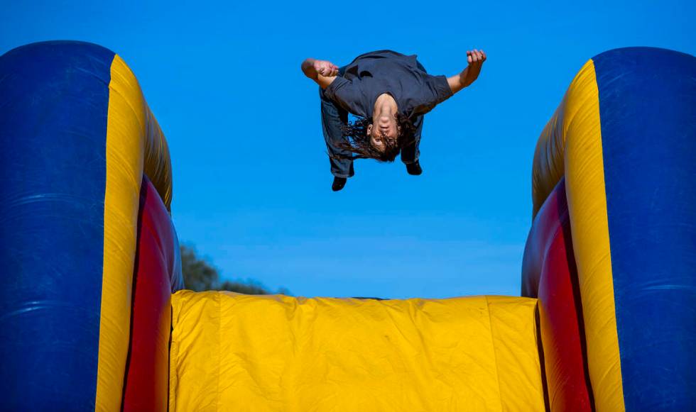 Raymond Sepulveda, 15, does a backflip off a bouncy slide as part of a celebration of life for ...
