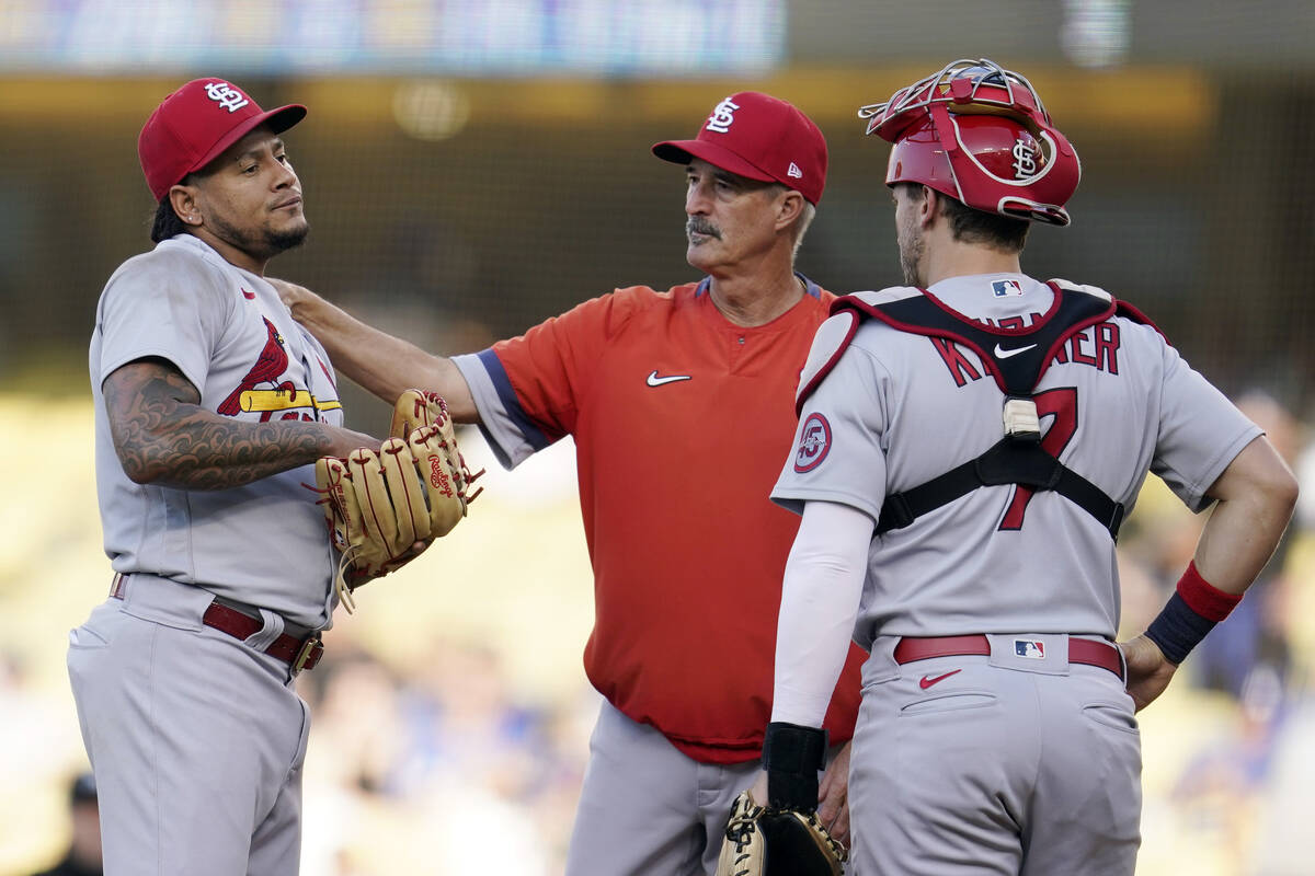 St. Louis Cardinals starting pitcher Carlos Martinez, left, gets a visit to the mound from pitc ...