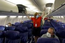 FILE - In this May 24, 2020, file photo, a Southwest Airlines flight attendant prepares a plane ...
