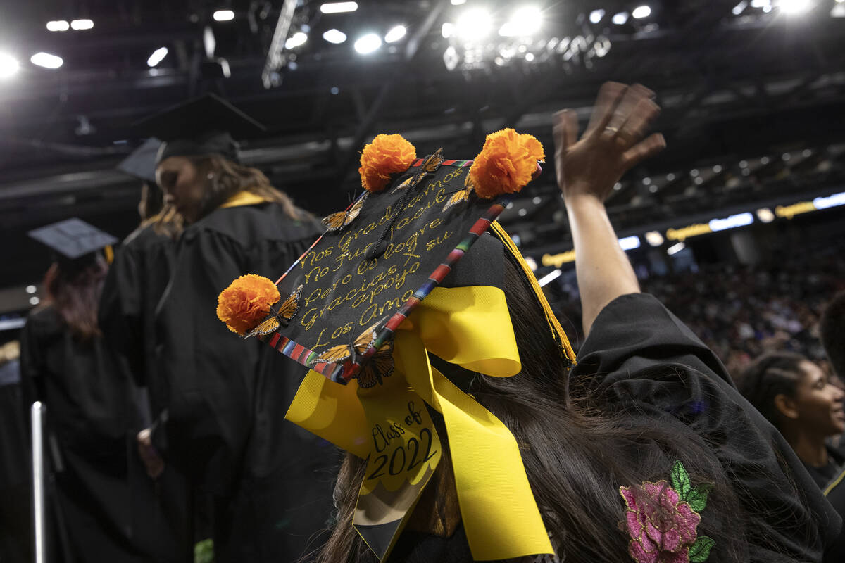A graduate waves to the crowd before walking across the stage during commencement for Nevada St ...