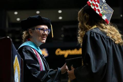 June Eastridge, dean of the school of nursing, congratulates a student during commencement for ...