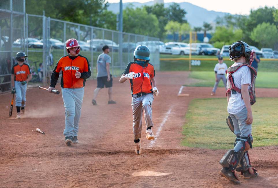Giants runner Maximilian Lewis (24) jumps up as he is about to tag home plate and score a run d ...